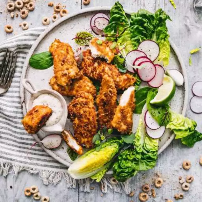 Crunchy Cheerios chicken nuggets with salad on a plate