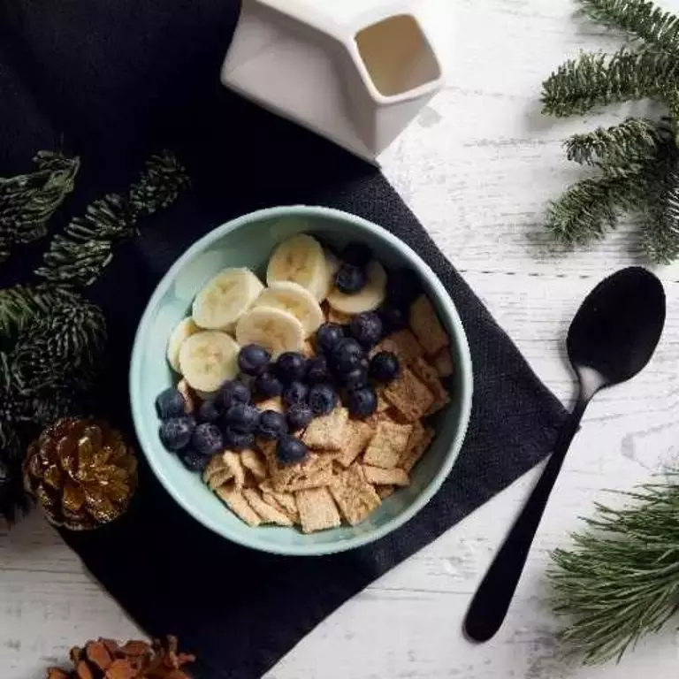 Bowl of Curiously Cinnamon cereal with blueberry and banana toppings