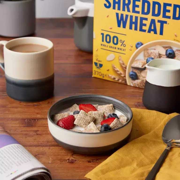 Shredded Wheat Bitesize bowl with a cup of tea and a jug of milk