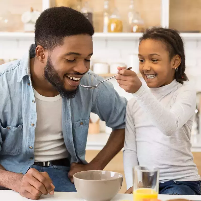 Child and Adult eating breakfast together