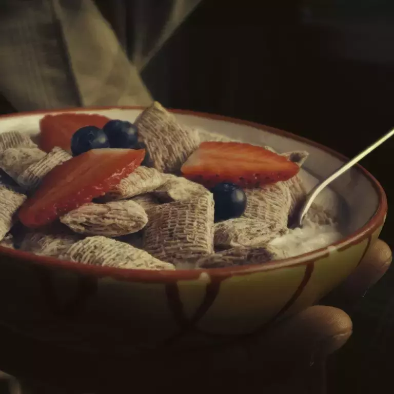 A bowl of Shredded Wheat Bitesize held in hand.