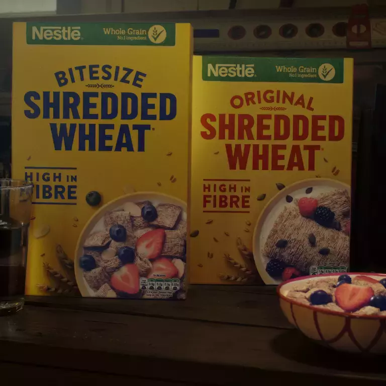 Shredded Wheat Bite Size and Shredded Wheat Original packs placed together on a bench.