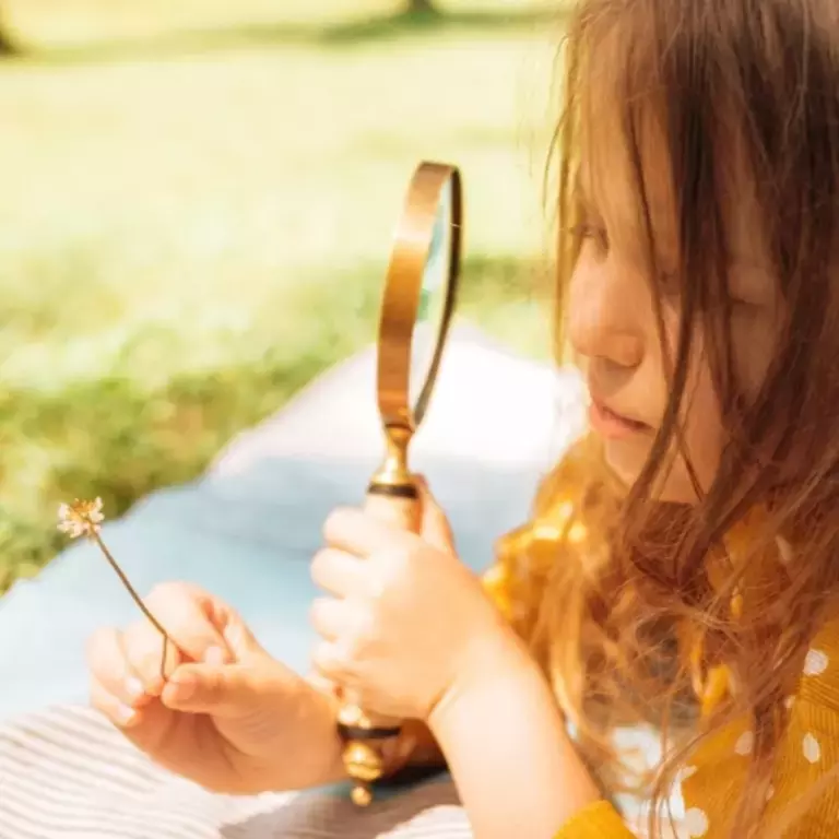 Girl looking through magnifying glass