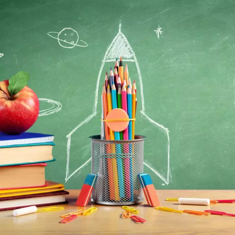 Rocket drawing, pencils, apple and books