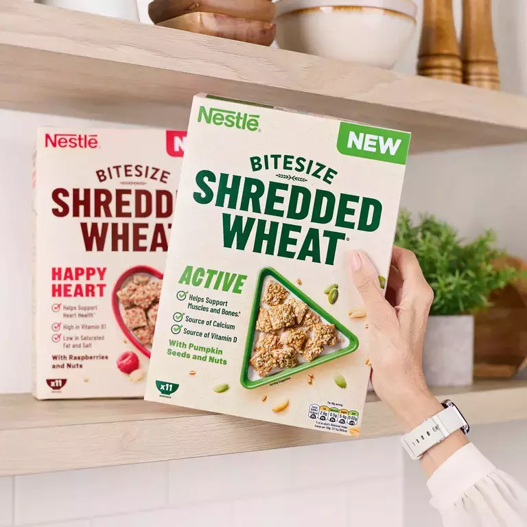 A hand getting a box of Shredded Wheat Active cereal off the shelf