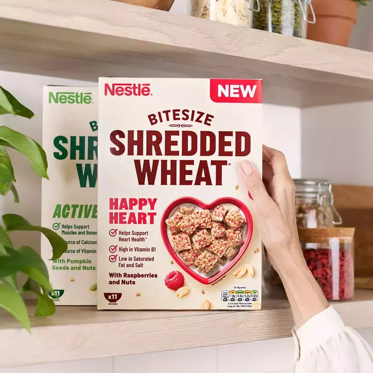 Hand getting a box of Shredded Wheat Healthy Heart cereal off the shelf